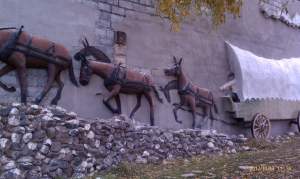 Relief sculpture on wall depicts old west scene.