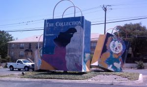Giant shopping bags in parking lot.