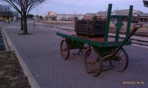 The luggage cart stands ready for the arrival of the train.
