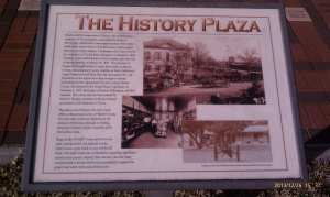 Behind the sign are bricks marking an historic timeline.
