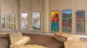 A gallery of fine art outside underneath the bridge.