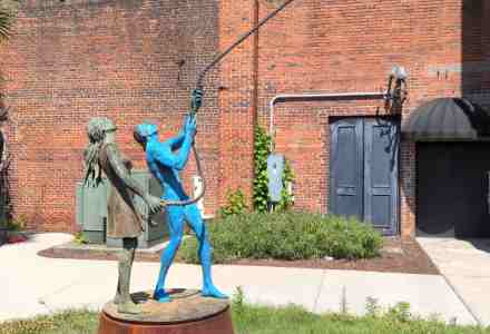Sculpture of two kids with a lasso around the moon.