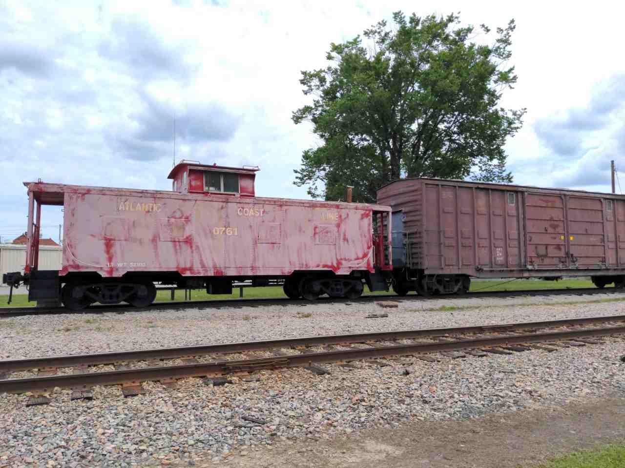 An old caboose and boxcar parked on a stretch of train track.