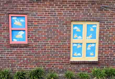 Murals on brick wall. They look like windows and through them you see flying tacos.