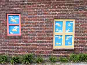 Murals on brick wall. They look like windows and through them you see flying tacos.