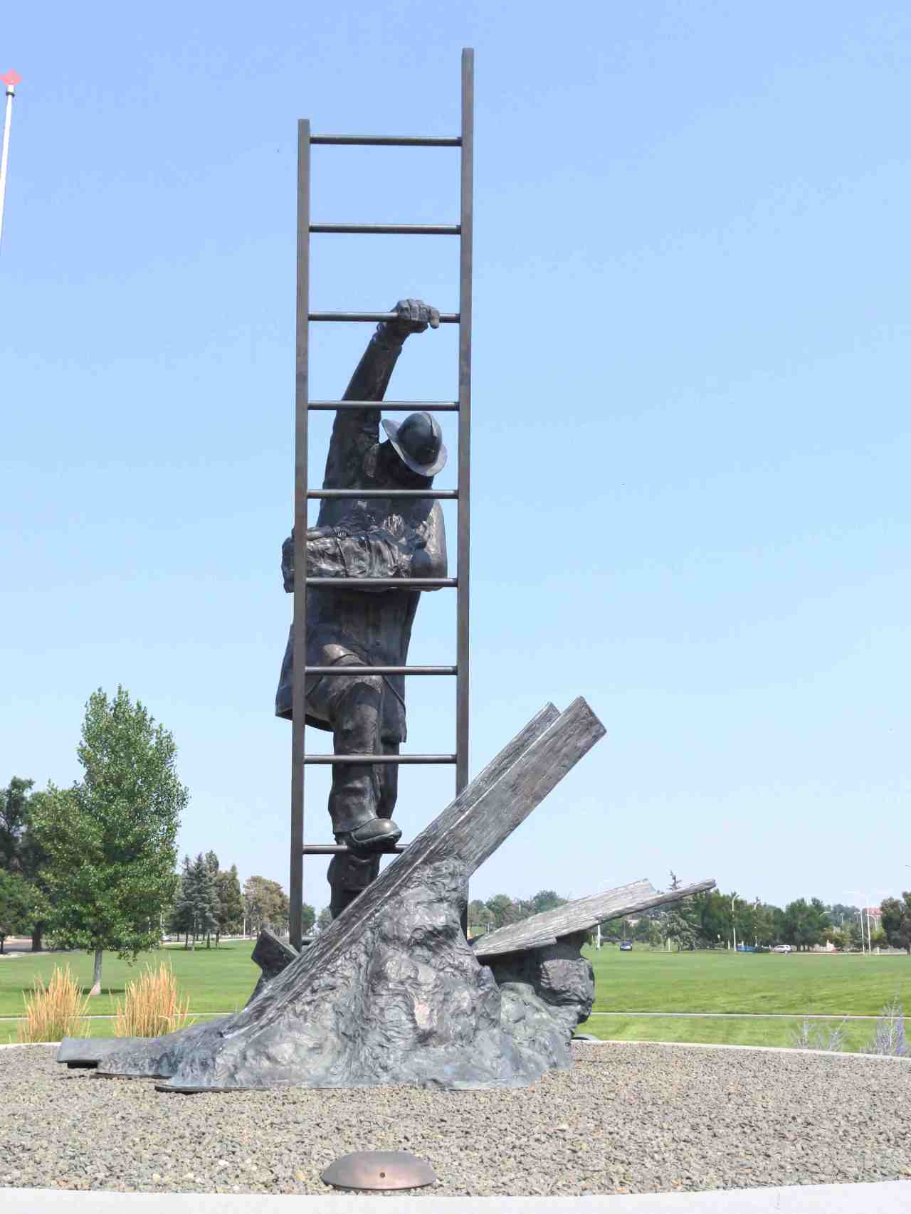 Sculpture of a firefighter saving a child and climbing a ladder.