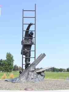 Sculpture of a firefighter saving a child and climbing a ladder.