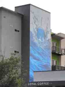 Mural of a bubble or blue ball falling into water and creating a splash.