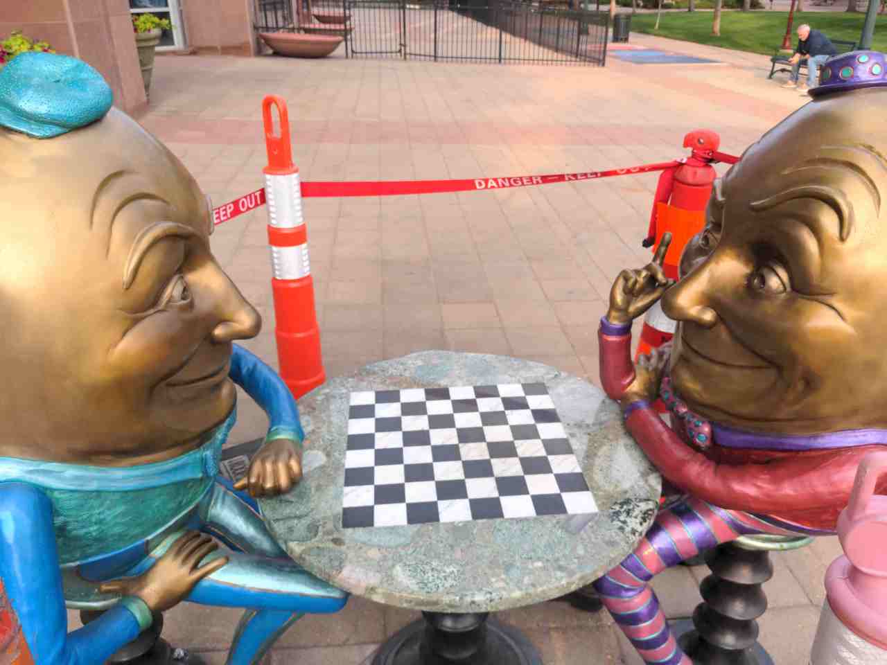 Two Humpty Dumptys sitting across a checker board from each other.