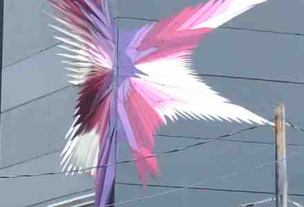 Art object on corner of building looks like an abstract phoenix.