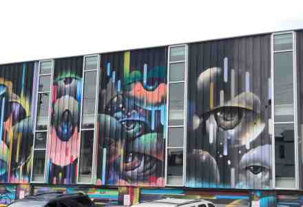 Mural on building wall of eyes looking at you.
