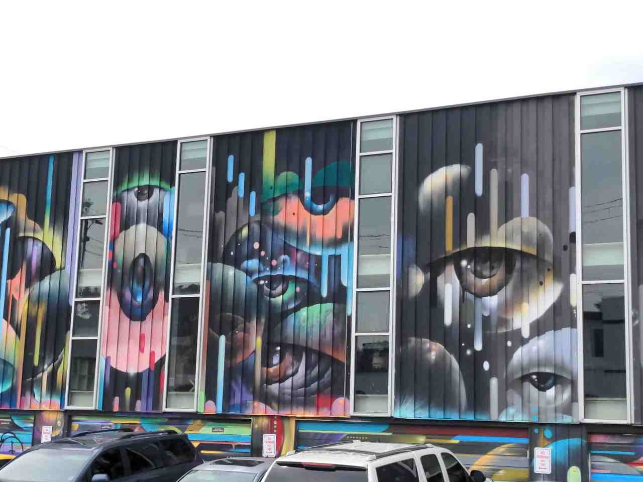 Mural on building wall of eyes looking at you.