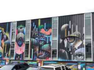 Mural on building wall of eyes looking at you.