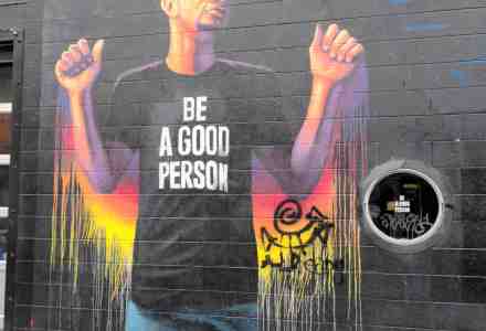 Mural of a man wearing a t-shirt that says "Be A Good Person."