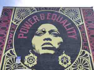 Mural of graphic design and portrait with words: "Power & Equality."