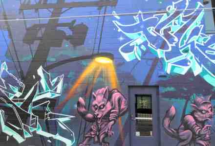 Mural of a dark street night with roaming wolf like creatures.