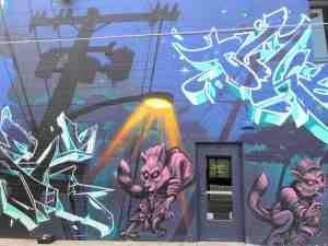 Mural of a dark street night with roaming wolf like creatures.